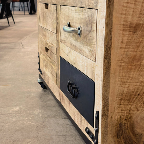 Vue rapprochée des tiroirs et ferronneries noires d’une armoire bar à vin en manguier massif, style industriel sur roulettes.